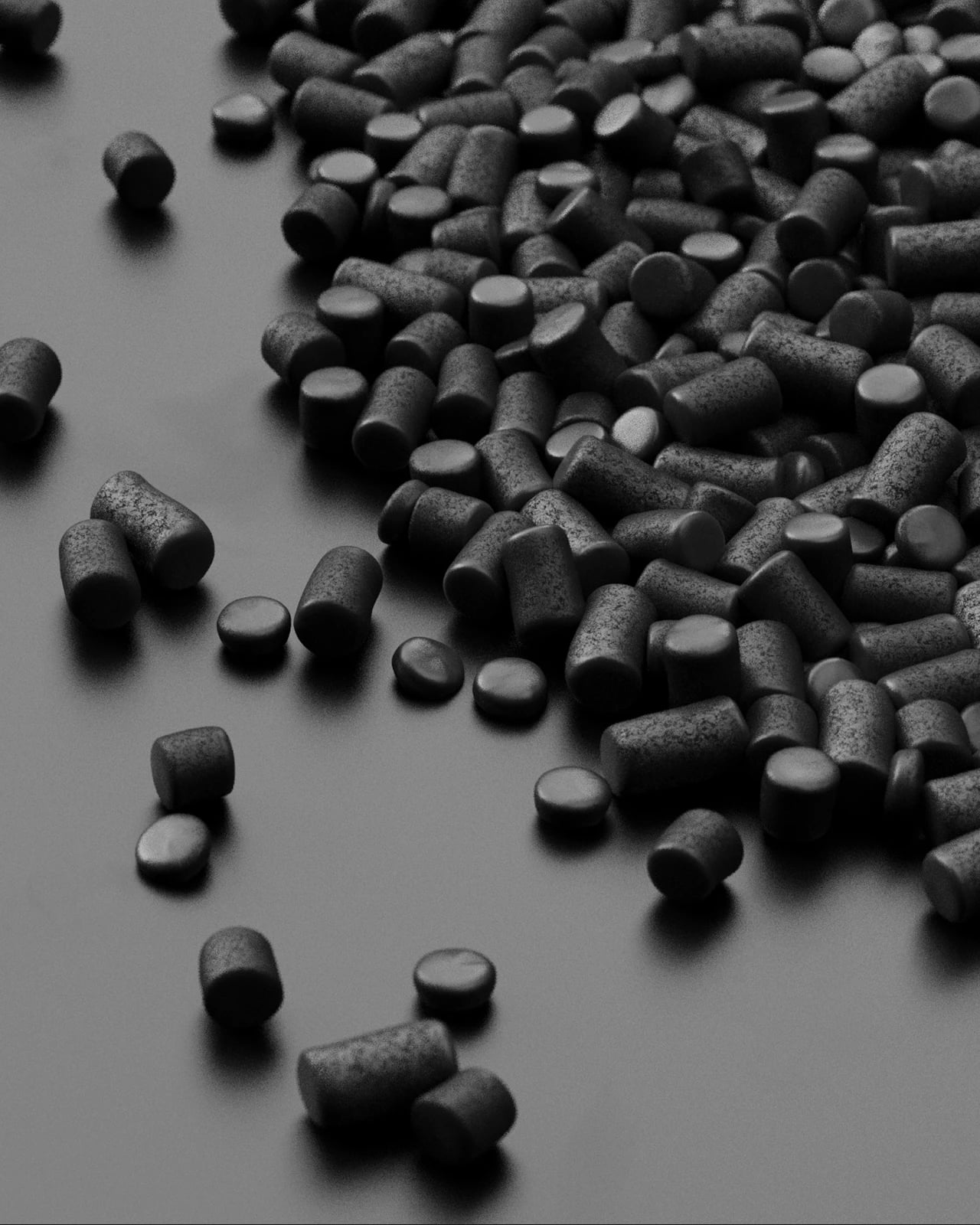 Close-up photograph of the carbon granules, cylindrical pellets scattered across a dark surface