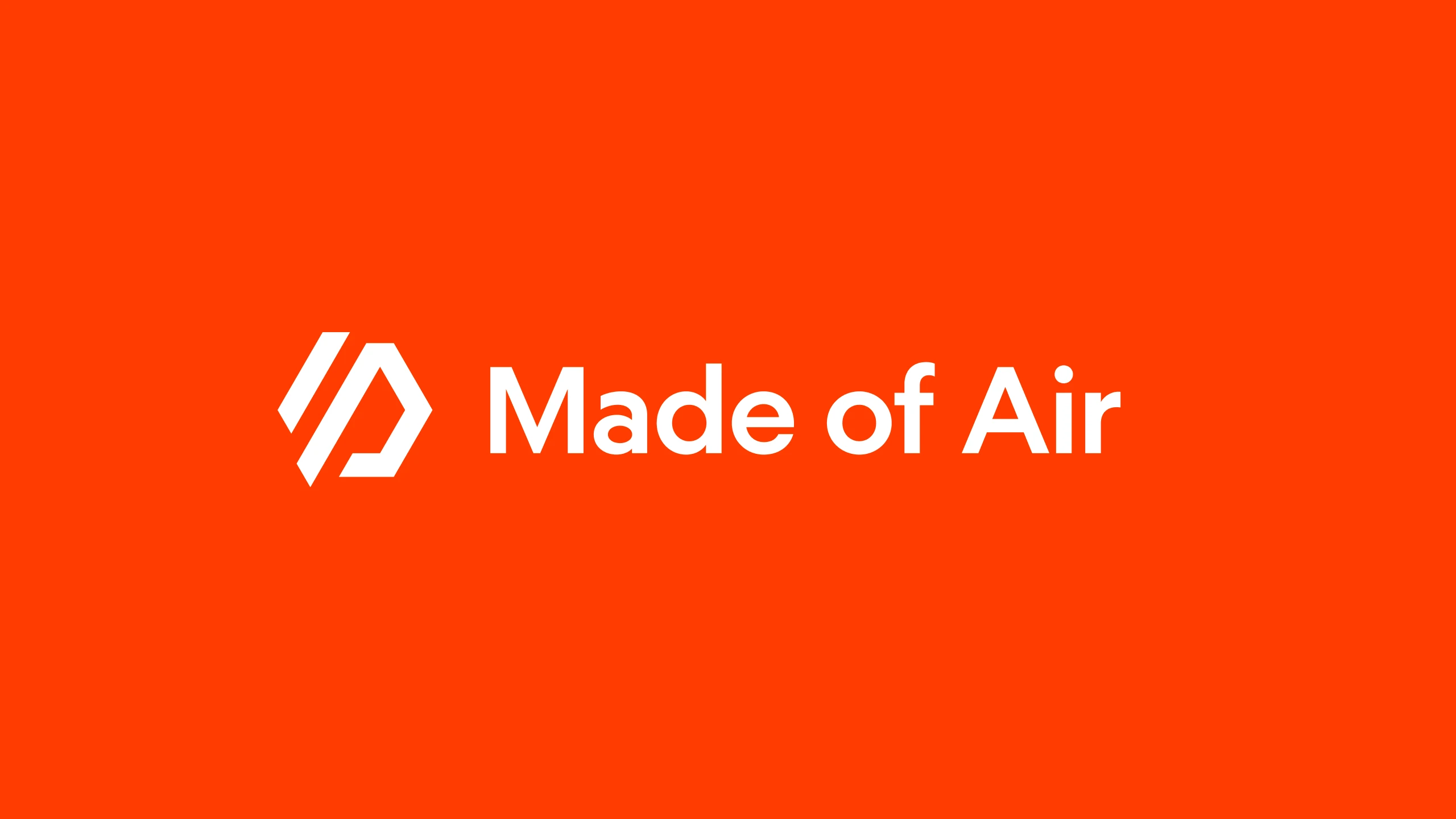 The Made of Air logotype in white on the brand orange, the angular mark set beside the wordmark
