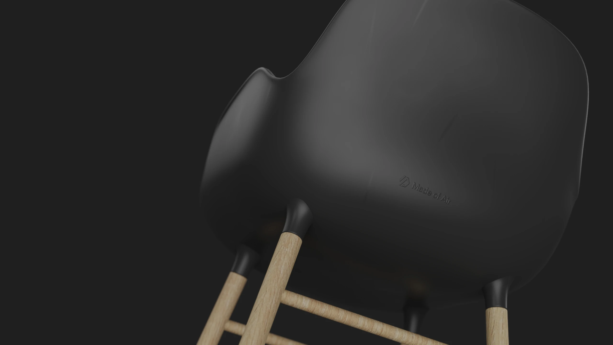 Rendered black moulded chair shell on pale wooden legs, seen from below with the Made of Air mark debossed in the back