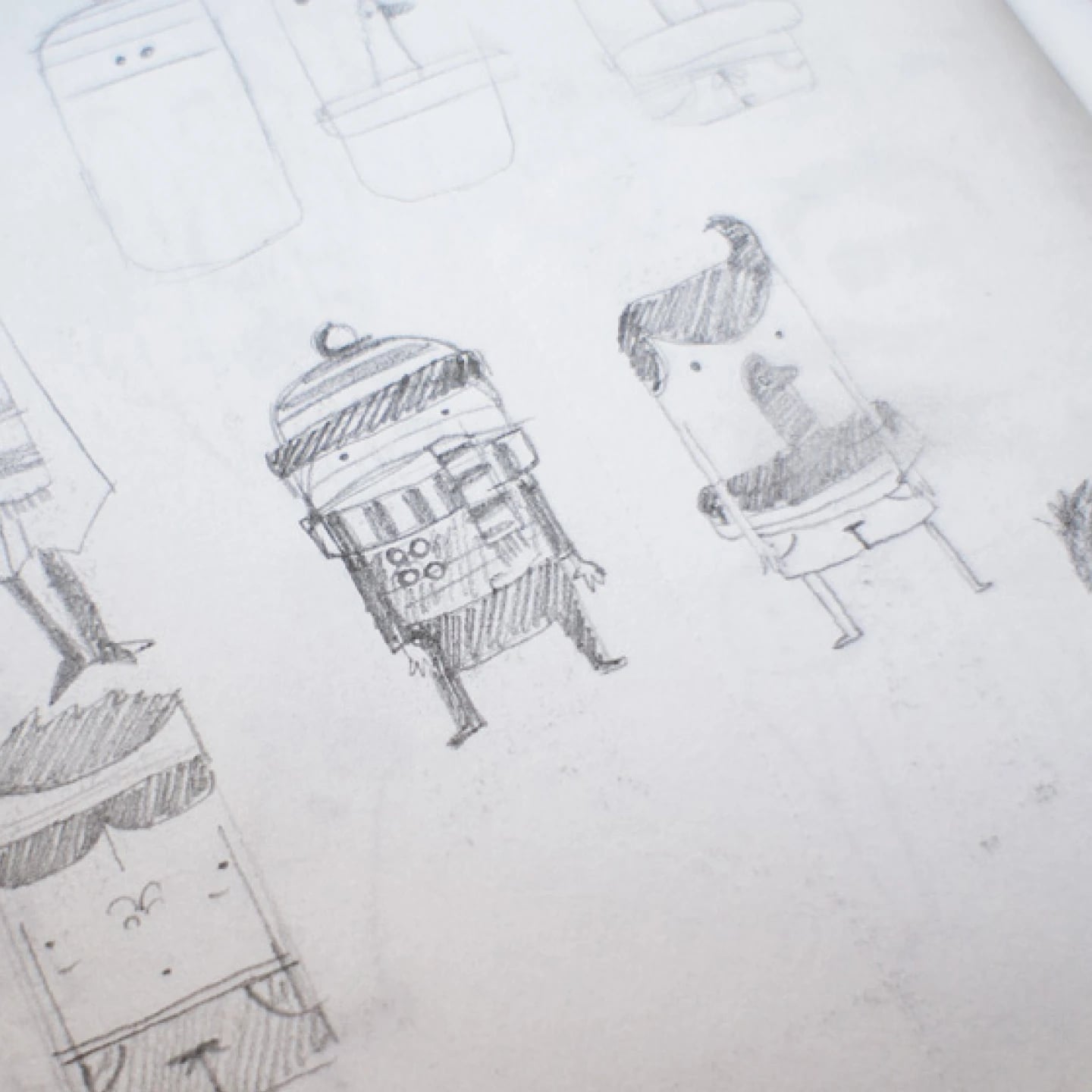 Pencil sketchbook page of early squircle characters, each a rounded rectangle body on two stubby legs